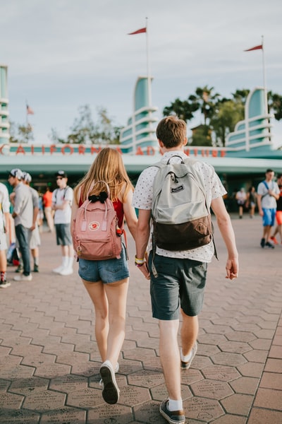 During the day, a couple hand in hand to the building
